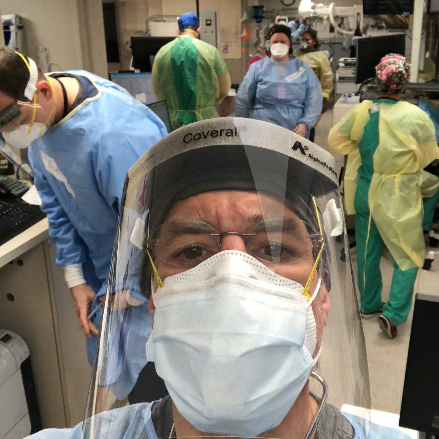 Image of David Katz, MD in full PPE gear with hospital personnel in background, also wearing full gear.