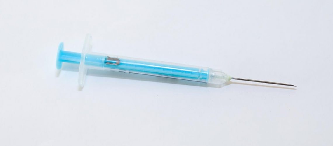 Blue syringe on a white background