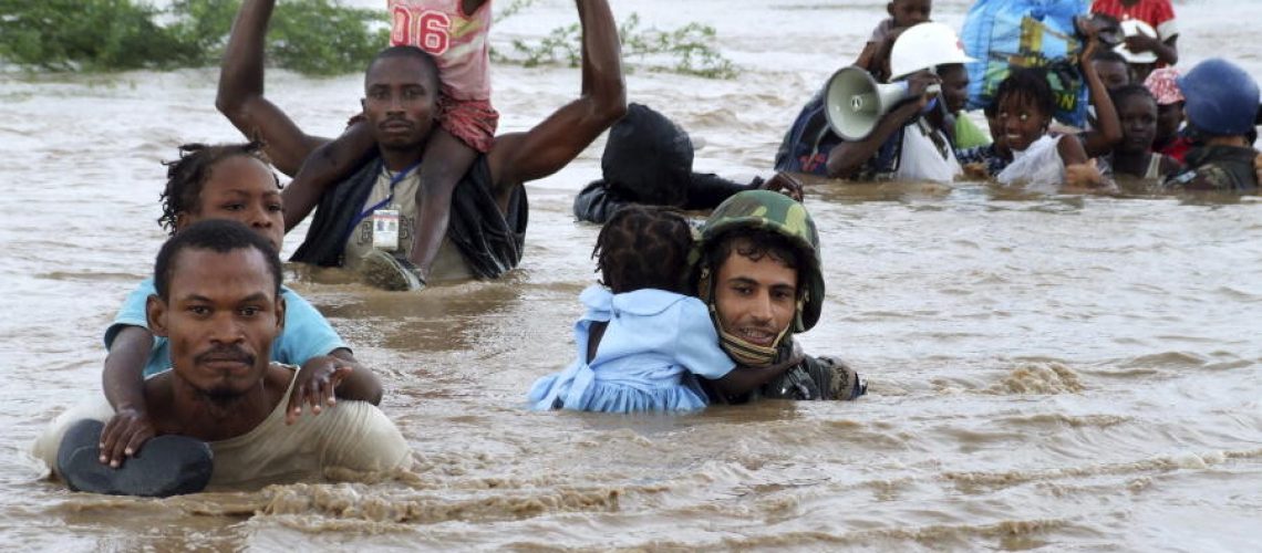 Black and brown military men saving young black children from flooding waters, carrying them through the water.